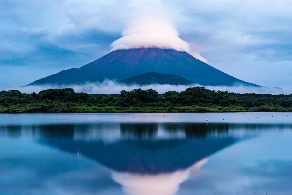 Vulkan Fuji in weißen Wolken spiegelt sich im See