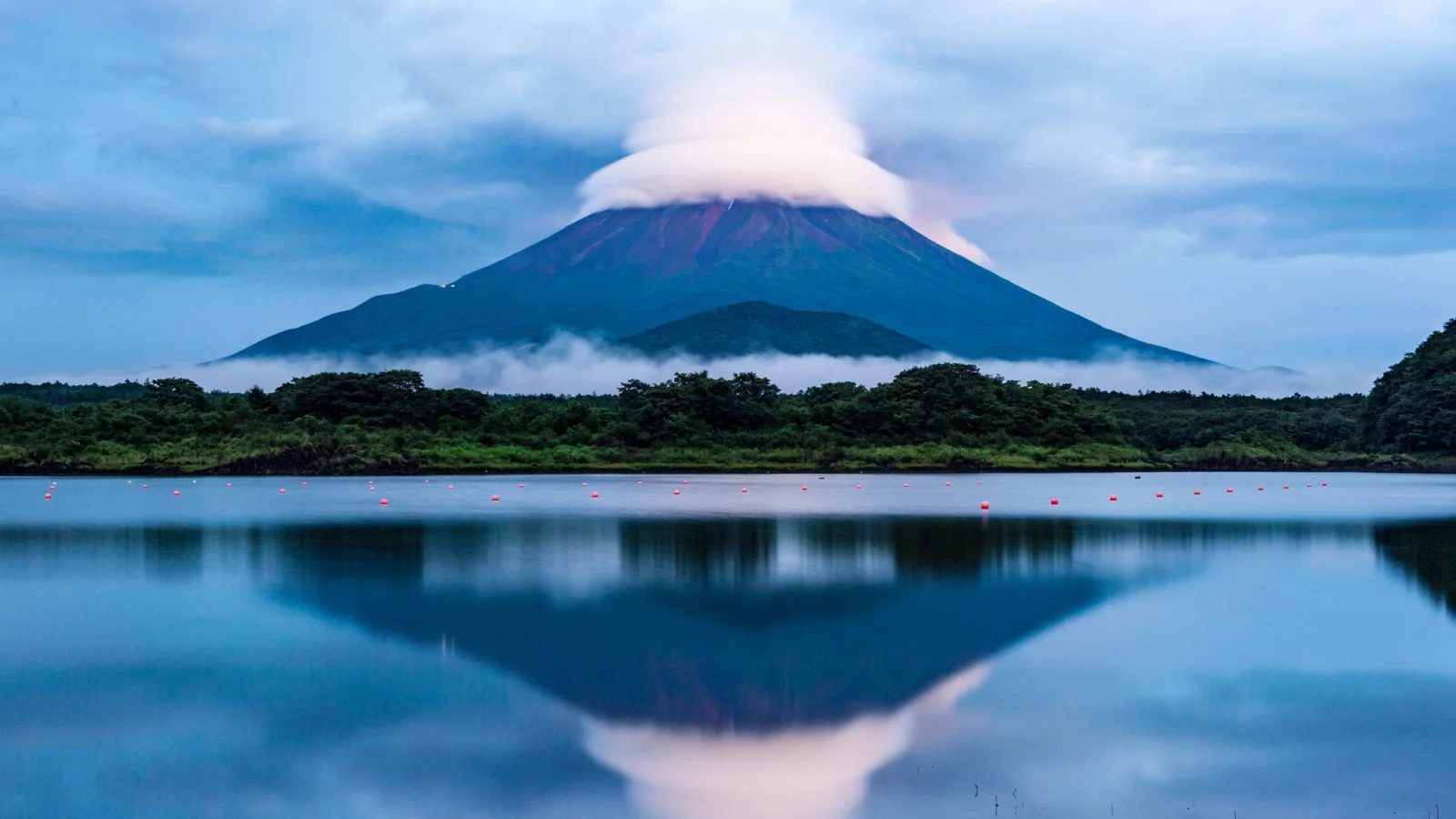 Vulkan Fuji in weißen Wolken spiegelt sich im See