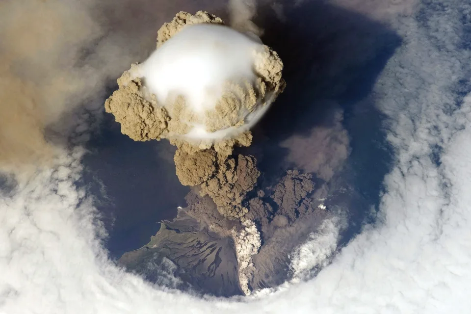 Wolken Rauch über Vulkan, Foto aus Weltraums