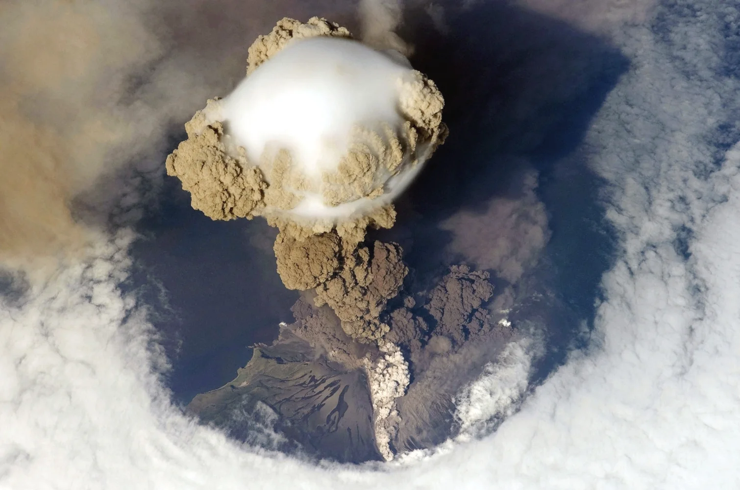 Wolken Rauch über Vulkan, Foto aus Weltraums
